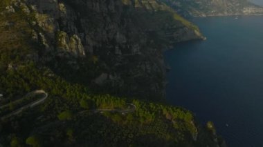 Deniz kıyısının yukarısında yüksek açılı viraj manzarası. Nefesini yukarı kaldır ve altın saatinde doğa manzarasını izle. Amalfi, İtalya.