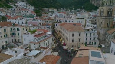 Tarihi şehir merkezinin sokaklarında yürüyen insanlar. Eski kasabadaki binaların havadan görünüşü. Amalfi, İtalya.