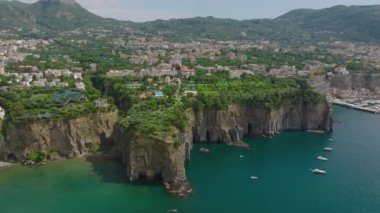 Engebeli sahil manzarası, sarp kayalıklar ve tepedeki evler. Deniz kıyısındaki bir turist kasabasında. Amalfi, İtalya.