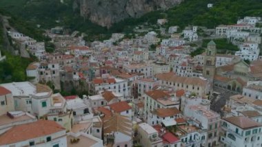 Tarihi şehir merkezindeki binaların yüksek açılı manzarası. Kasabanın etrafındaki kıyı ve kıyı manzarasının tersten görüntüsü. Amalfi, İtalya.