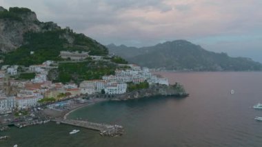 Seyahat noktasındaki deniz kıyısının hava panoramik görüntüsü. Eski sahil kasabasında binalar, sudan yükselen yüksek kayalık yamaçlar. Amalfi, İtalya.