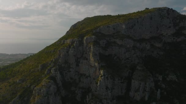 自然の中で丘の上に驚くほど高い岩壁と緑の斜面 町の建物を背景に Amalfi イタリア — ストック動画