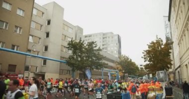 Şehir merkezindeki etkinlik parkurunda koşan sporculara eğil. Maraton koşu yarışı, Berlin, Almanya.