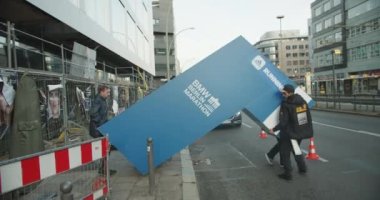 Bir grup organizatör pist hazırlıyor. Sokakta zaman çizgisi taşımak ve kurmak. Maraton koşu yarışı, Berlin, Almanya.