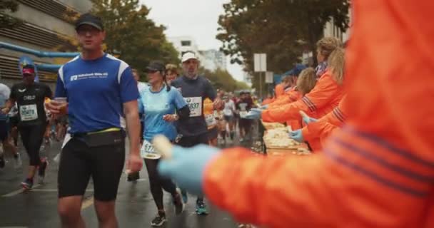 身穿橙色夹克的志愿者在运动会期间为运动员提供新鲜水果 马拉松比赛 德国柏林 — 图库视频影像