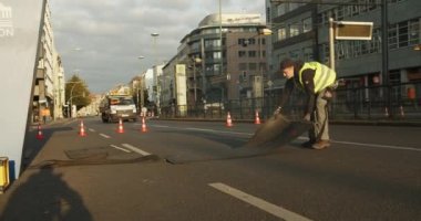 Organizatörler caddeyi spor akşamına hazırlıyorlar. Kauçuk pedleri zaman çizelgesine yerleştiriyorum. Şehir merkezindeki geniş cadde. Maraton koşu yarışı, Berlin, Almanya.