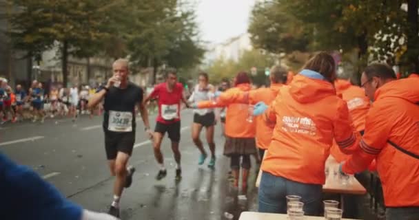Wolontariusze Stacji Gastronomicznej Oferują Szklanki Wody Dla Sportowców Biegających Kursie — Wideo stockowe