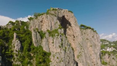 Güneşli bir günde, yüksek uçurumun tepesindeki modern tasarım konutunun havadan yükselen görüntüleri. Capri, Campania, İtalya.