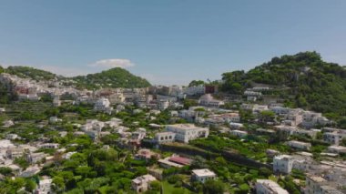 Şehir merkezindeki evlerin hava panoramik görüntüleri. Yokuşta yeşil bahçeli binalar. Capri, Campania, İtalya.