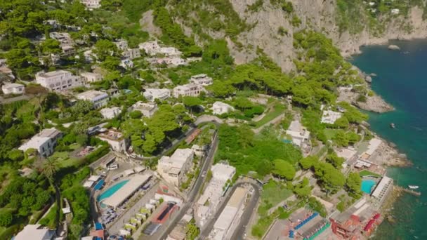 旅行先での海沿岸の空中降下映像 高い岩に囲まれた海辺の観光リゾート カプリ カンパニア イタリア — ストック動画