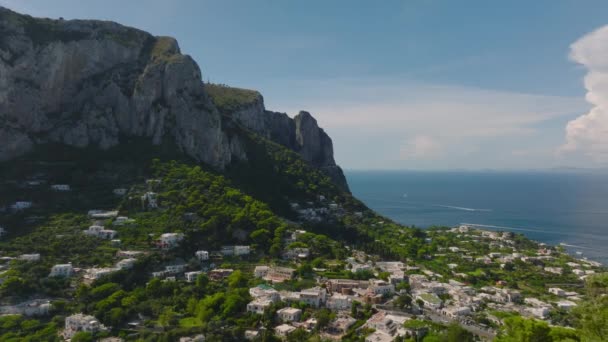 高い岩壁の下の海岸沿いの町の素晴らしい景色 石の塊の上に有名なヴィラCastiglioneの後方明らかに カプリ カンパニア イタリア — ストック動画