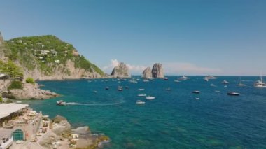 Akdeniz kıyılarının güzel manzarası. Gemiler kıyıya demir attı. Arka planda sudan yükselen büyük kayalar. Capri, Campania, İtalya.
