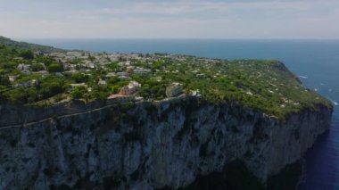 Dik yamaçların yakınındaki hava manzarası, deniz kıyısındaki kayalık uçurumlarda geçen yol. Capri, Campania, İtalya.