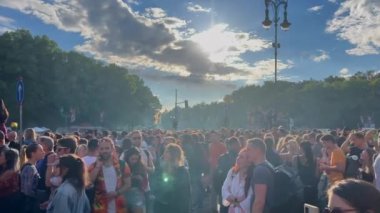 Çoğunlukla Christopher Caddesi 'ndeki etkinliklerde gençler. Bulutların arasından parlayan güneşe bak. LGBT festivali, Berlin, Almanya.