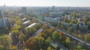 Sonbahar şehrindeki çok raylı demiryolu hattında birbirinin yanından geçen trenlerin hava görüntüsü. Berlin, Almanya.