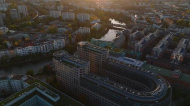 Spree Nehri kıyısındaki şehir merkezindeki modern binaların hava kaydırak ve pan görüntüleri. Gün batımında şehrin panoramik görüntüsünü ortaya çıkar. Berlin, Almanya.