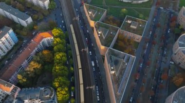 Altın saatinde şehir merkezinden geçen trenin hava görüntüsü. İnşaat alanının yakınındaki S Bahn trenini takip ediyorum. Berlin, Almanya.
