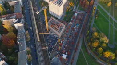 Sonbahar şehrindeki modern yüksek binaların inşaat alanının yüksek açılı görüntüsü. Ana demiryolu yakınında yüksek kule vinci çalışıyor. Berlin, Almanya.