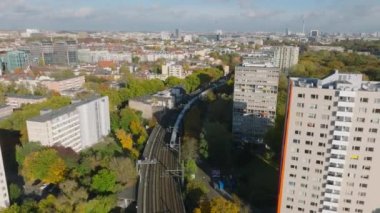 Yüksek hızlı trenin geçişini takip ederek yüksek binaların etrafından dönün. Berlin, Almanya.