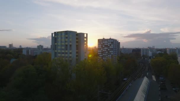 前方の住宅都市のバラの背の高いアパートの建物の間に日没で飛ぶ ドイツ ベルリン — ストック動画