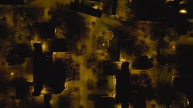 Geceleri büyük şehirlerdeki yerleşim yerlerinin üzerinden uç. Konutlardaki çok katlı apartmanların en aşağı manzarası. New York City, ABD.