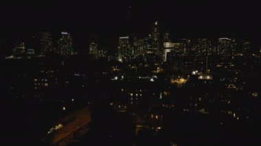 Gece şehrindeki binaların hava panoramik görüntüleri. Yüksek katlı dairelerde ya da ofis kulelerinde ışıklandırılmış pencereler. New York City, ABD.