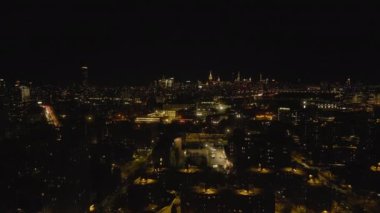 Gece şehrinin üzerinde ileri uç. Ana yolda yoğun trafik var, arka planda yüksek gökdelenler var. New York City, ABD.