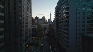 Sokağın üzerinden uç ve ünlü Washington Meydanı Kemerini göster. Alacakaranlıkta Metropolis. New York City, ABD.