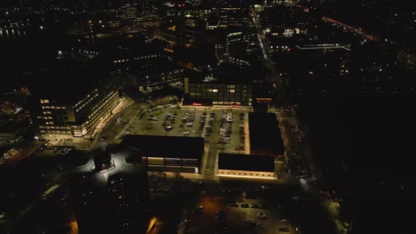 Wysoki Kąt Widzenia Podświetlanego Parkingu Otoczonego Budynkami Dzielnicy Miejskiej Nocna — Wideo stockowe