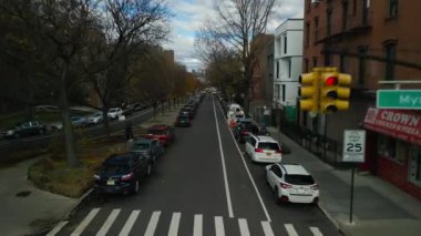 Sonbahar şehrinde bir sokak. Şehir merkezindeki yol boyunca park edilmiş sıra sıra arabalar. New York City, ABD.