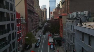 Şehir merkezindeki caddenin üzerinde ilerliyorlar. Tek yön boyunca çok katlı binalar. New York City, ABD.