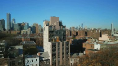 Modern apartman binasının havadan kayma ve pan görüntüleri. Çevredeki gelişmelerin çok üstünde. Brooklyn şehir merkezindeki gökdelenler arka planda. New York City, ABD.