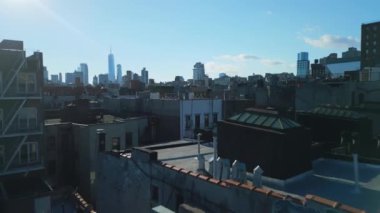 İleri uçaklar şehir merkezinin üzerinde. Şehirdeki apartmanların çatıları dümdüz. Arka planda şehir merkezindeki gökdelenler. New York City, ABD.