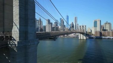 Brooklyn Köprüsü boyunca arka planda ikonik Aşağı Manhattan gökdelenleri ile ilerliyoruz. New York City, ABD.