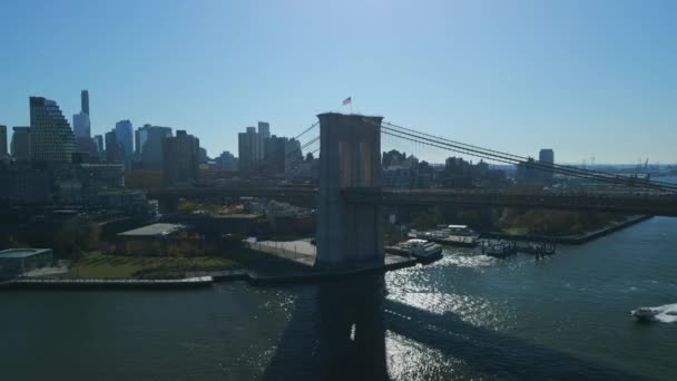 布鲁克林大桥河岸支柱和城市建筑物的空中滑行和平板镜头与蓝天相映成趣 New York City Usa — 图库视频影像