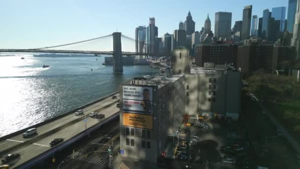 Légifilm Felvétel Városról Brooklyn Híddal Manhattani Felhőkarcolókkal Forgalmas Autópályával Folyóparton — Stock videók