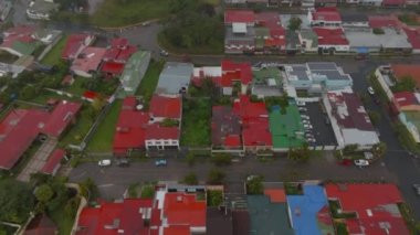 High angle view of low houses in residential urban borough. Aerial view of town with lot of greenery, trees and parks. San Jose, Costa Rica.