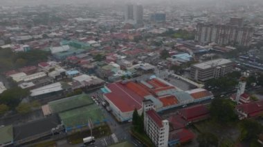 Aerial footage of urban borough in capital. Rainy and hazy day in tropical destination. San Jose, Costa Rica.
