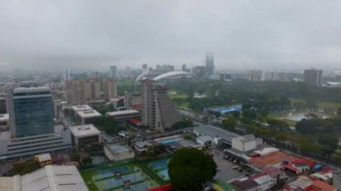Forwards fly above town development on rainy day. Urban borough and a Sabana Park with national stadium. San Jose, Costa Rica.