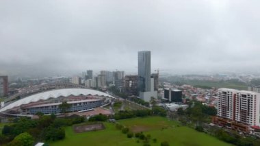 Aerial footage of famous football stadium, park and surrounding buildings in city. Estadio Nacional de Costa Rica in La Sabana Park. San Jose, Costa Rica.