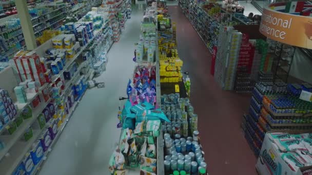 進む通路や空の店で棚の上を閉じて飛ぶ 営業時間外の大型スーパーの内装 — ストック動画