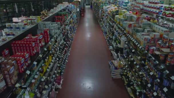 前方の通路や棚の上に食料品と飛ぶ 営業時間外の大型スーパーの内装 — ストック動画