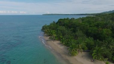 Flying above the tropical wild rainforests and crystal clear caribbean waters. Overhead view of wild and rural landscape of exotic and tropical sandy beaches island