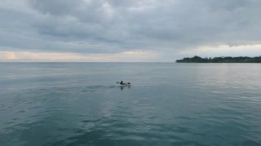 Puerto Viejo, Costa Rica - August 2022: Man paddling a one person kayak canoe offshore in Pacific Ocean. A man paddling a kayak in open deep water offshore in the sea