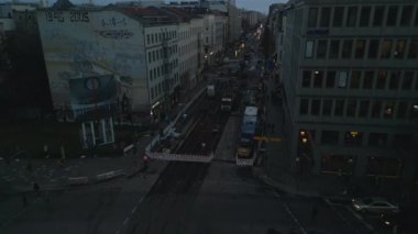 Fly above street in city in evening. Refurbishment of tram tracks and switches. Machinery parked on construction site. Berlin, Germany.