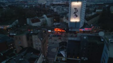 Aerial view of colour illuminated banners and storefronts of shops and clubs along famous Reeperbahn street at twilight. Hamburg, Germany.