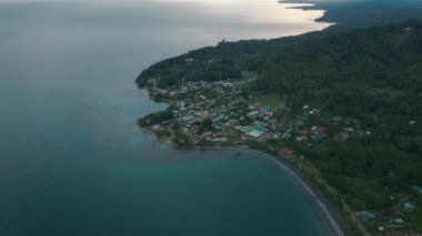 Küçük sahil kasabasının havadan görünüşü ve alacakaranlıkta tropikal deniz kıyısının panoramik manzarası. Puerto Viejo, Kosta Rika.