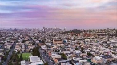 Günbatımında Metropolis 'teki yerleşim bölgesinin üzerinde uçuyor. Şehir merkezindeki modern gökdelenler. Yüksek hızda atış. San Francisco, California, ABD.