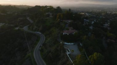 Alacakaranlıkta varoşlardaki tepelerde yol alan araçların yüksek açılı görüntüsü. Los Angeles, Kaliforniya, ABD.
