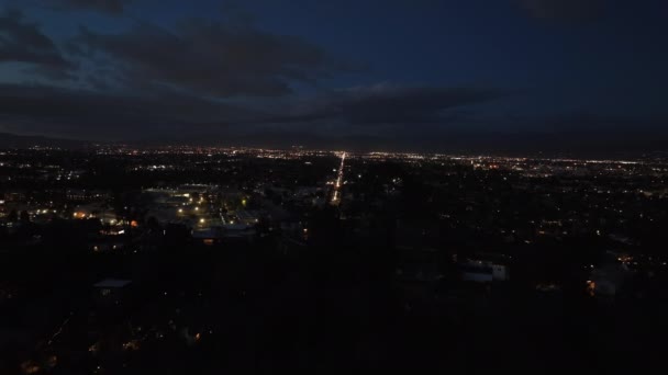 Przód Przelatuje Nad Wzgórzami Ujawnia Oświetlone Ulice Skrzyżowanie Mieście Wieczorem — Wideo stockowe